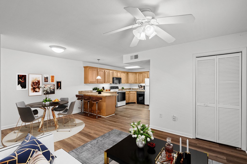 A living room with a storage closet, ceiling fan, and dining space at Malvern Hill Apartment Homes, 66103, Kansas