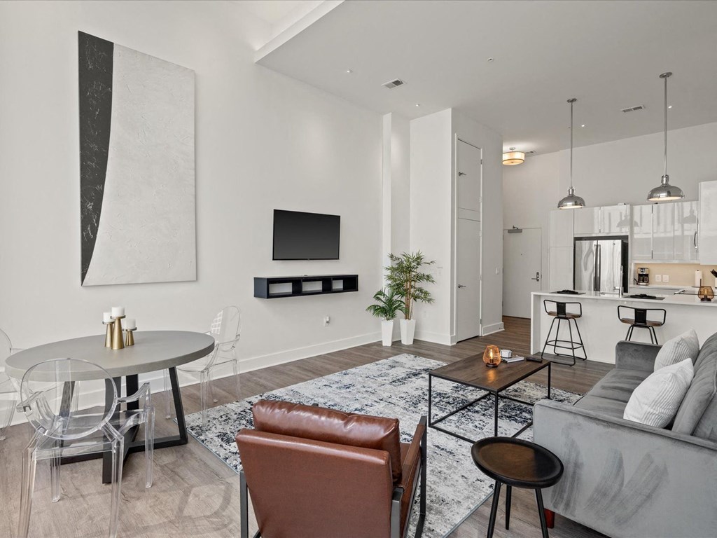 a living room with white walls and hardwood floors at Sky On Main Apartments, Missouri City, Missouri