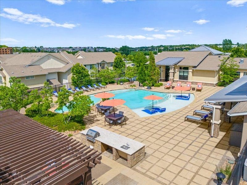 an aerial view of an outdoor pool with tables and umbrellas