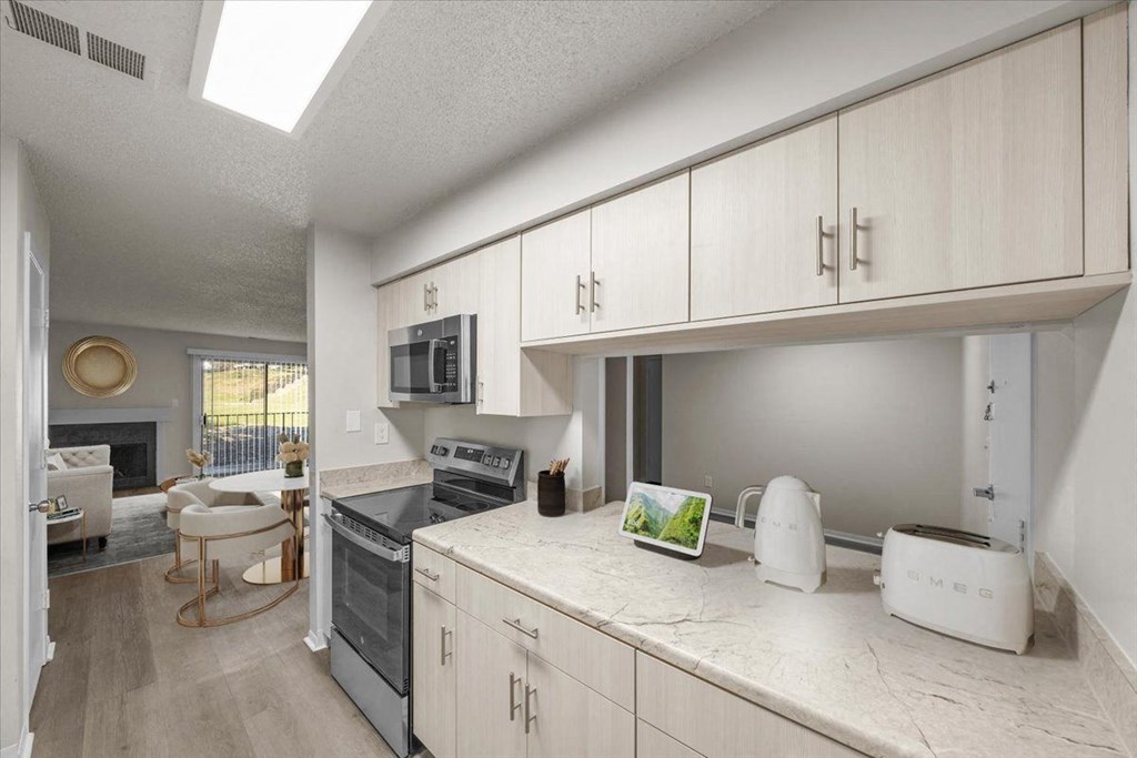 A kitchen with white appliances and cabinets. at Cloverset Active Adult Apartments, Kansas City 64114
