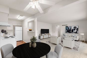 A living & dining area with an open layout, ceiling fan, and a combination of carpet and hardwood floors.