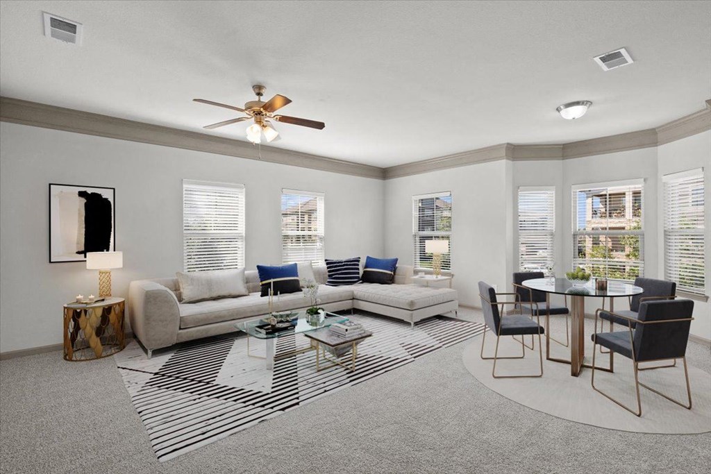 a living room with a couch a table and a ceiling fan