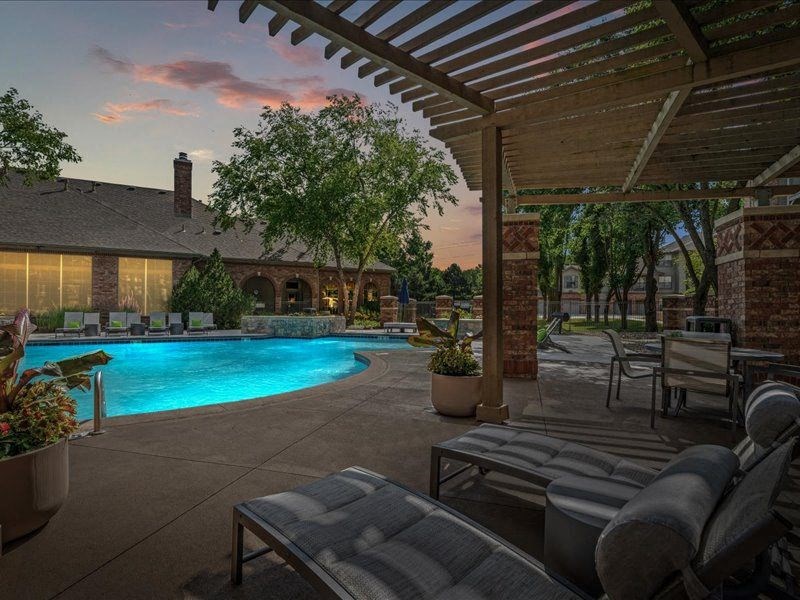 a backyard with a swimming pool and patio furniture