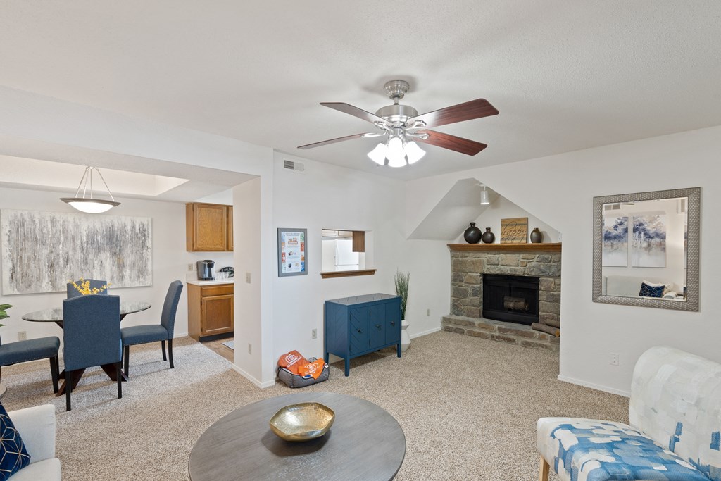 a living room with a fireplace and a ceiling fan at Waterford Place Apartments & Townhomes, Overland Park, 66210