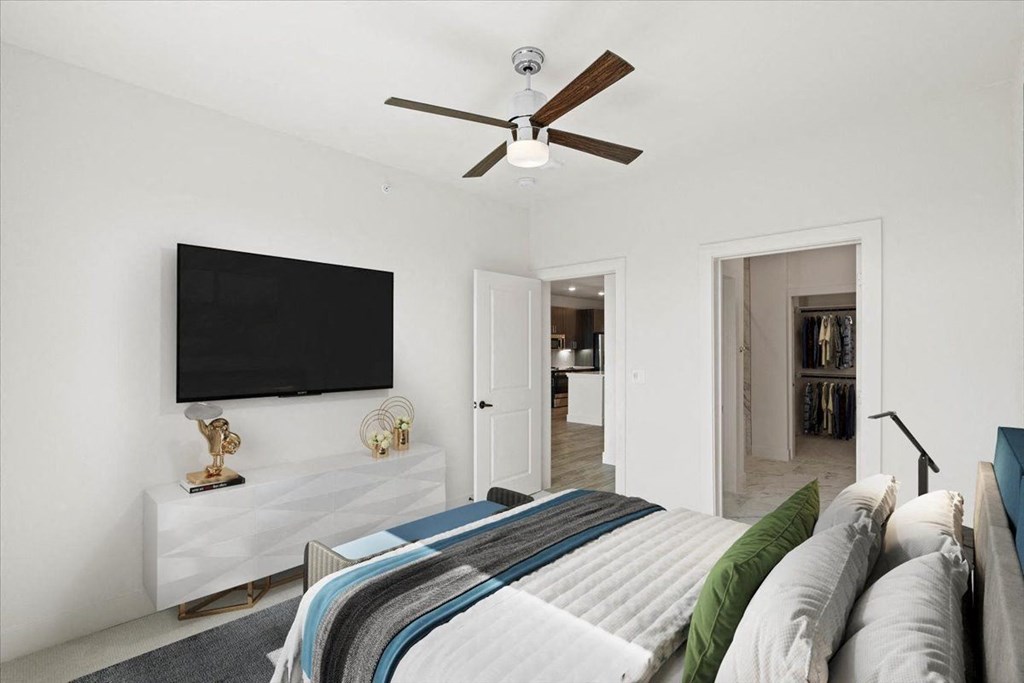 a bedroom with a bed and a ceiling fan