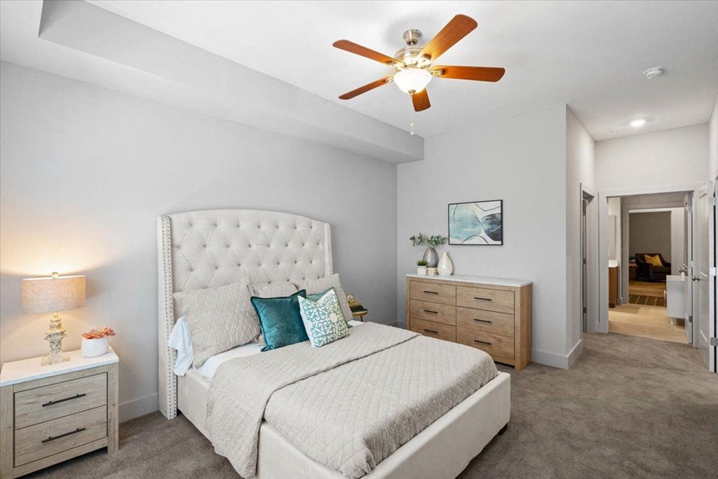 a bedroom with a large bed and a ceiling fan