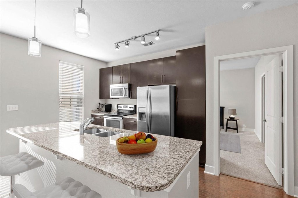 a kitchen with a granite counter top and a stainless steel refrigerator