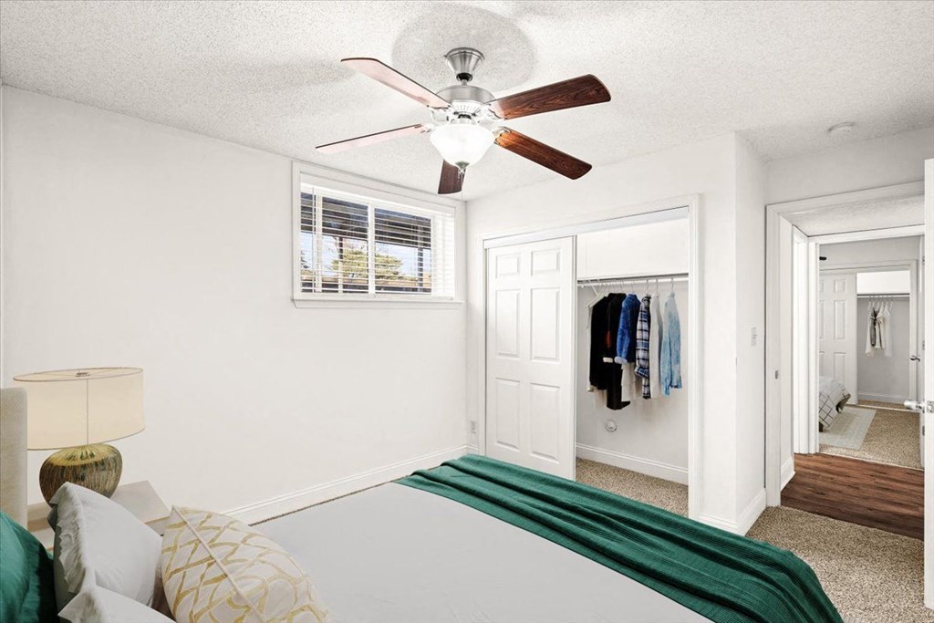 a bedroom with a bed and a ceiling fan