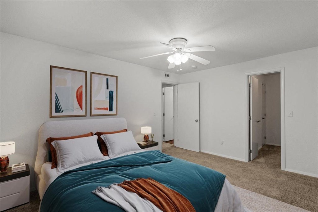 a bedroom with a bed and a ceiling fan