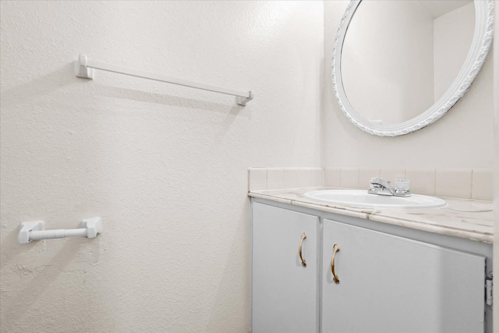 a white bathroom with a sink and a mirror