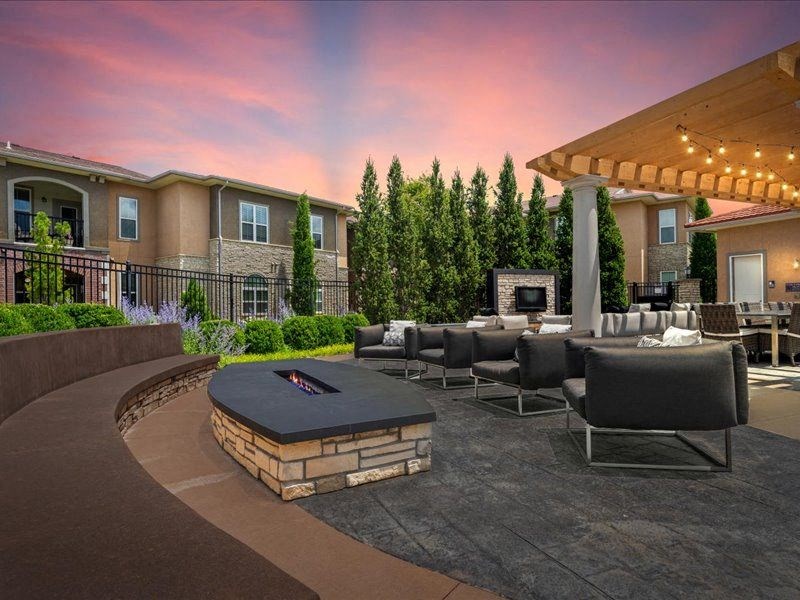 a large patio with chairs and a fire pit