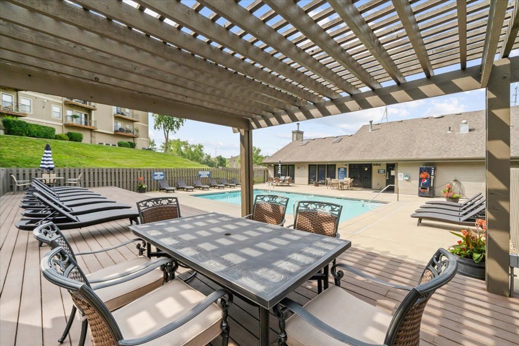 A wooden table and chairs are set up on a patio.