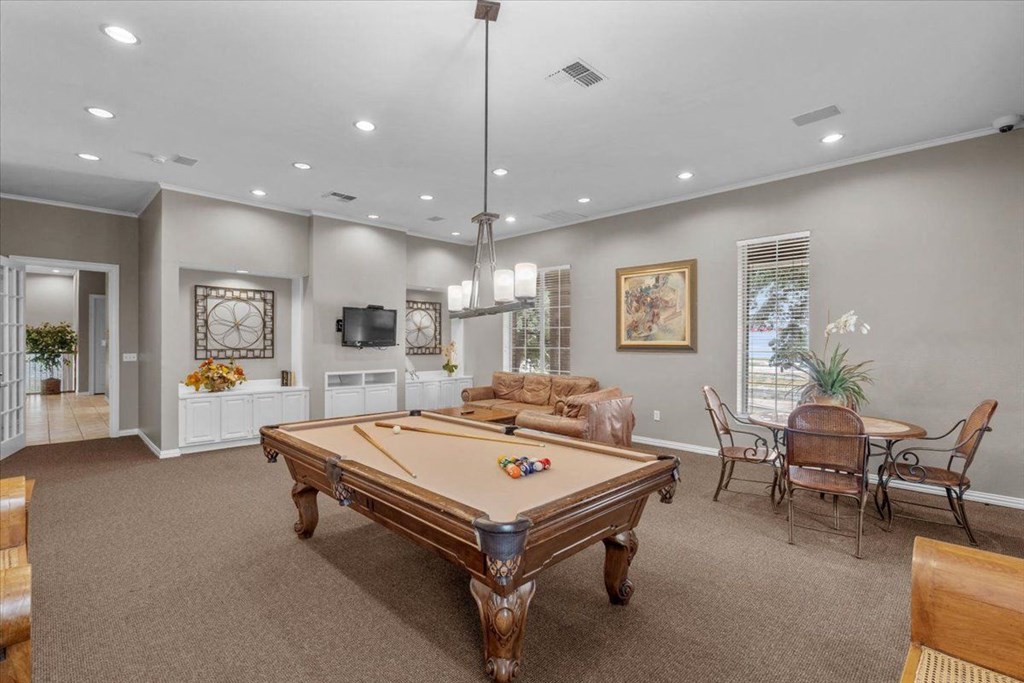 a game room with a pool table and a television at The Clairborne Apartment Homes, Grand Prairie, TX, 75050
