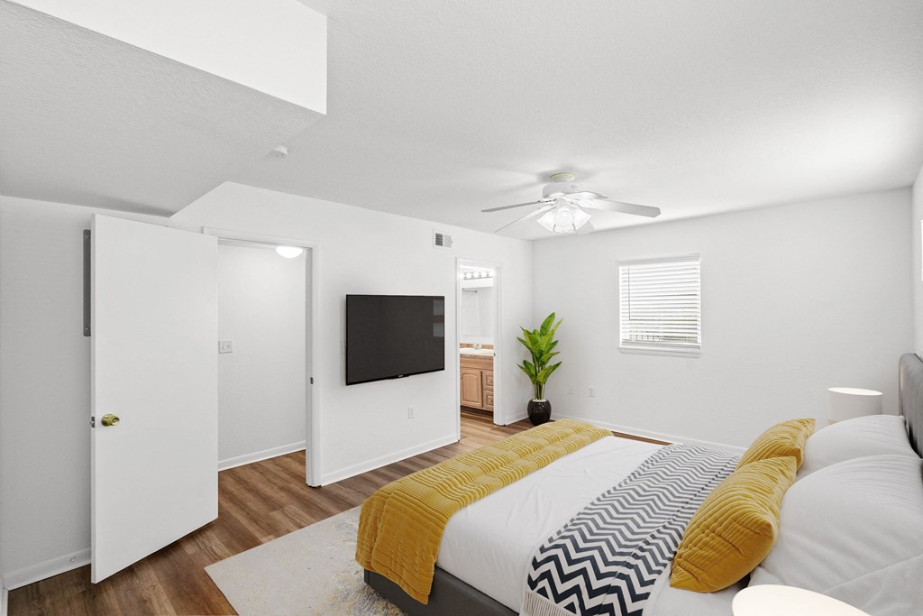 a bedroom with a large bed and a ceiling fan at Malvern Hill Apartment Homes, 66103