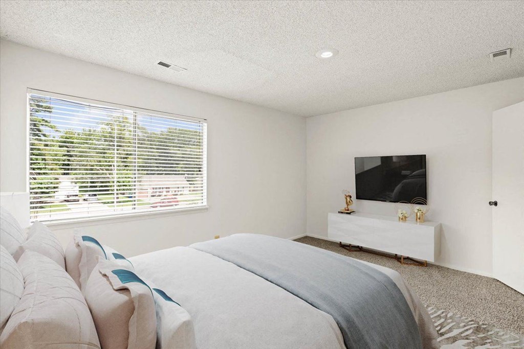 Bedroom with a TV at Bremerton Park Apartment Homes , Prairie Village, KS