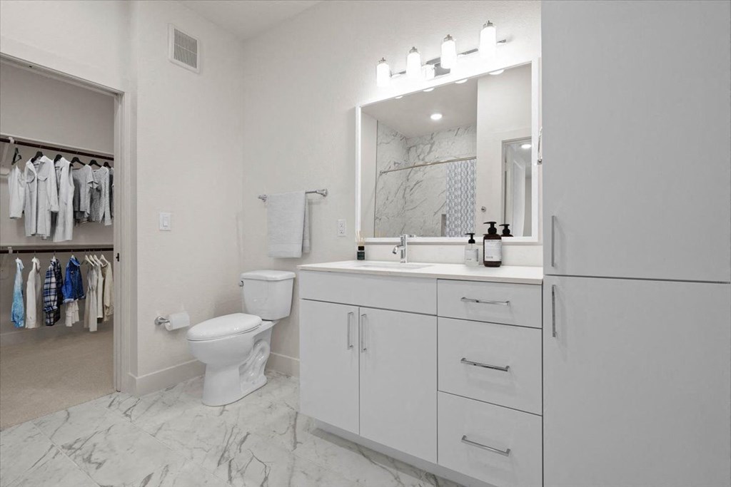 a white bathroom with a toilet and a sink