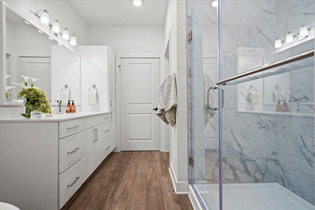 a white bathroom with a shower and a sink