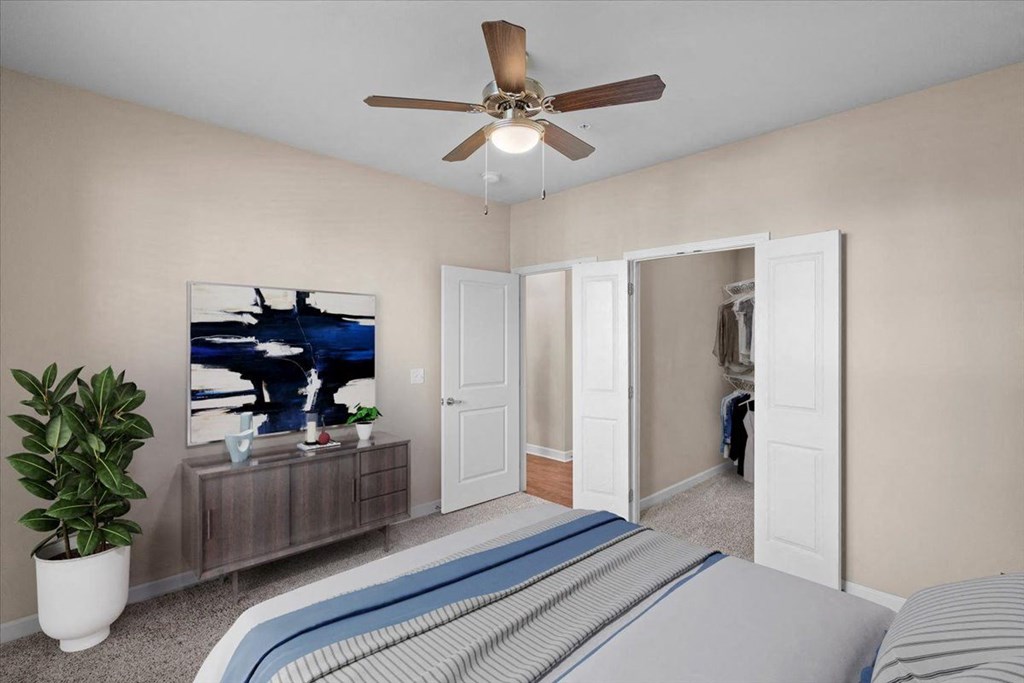a bedroom with a large bed and a ceiling fan