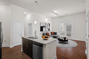 A modern kitchen with dark wood floors and white walls.