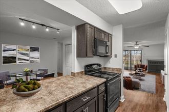 a kitchen and living room with a granite counter top