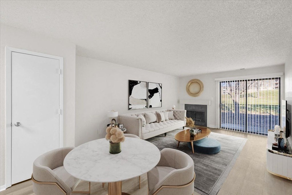 A living room with a white couch, a coffee table, and a large window at Cloverset Active Adult Apartments, Kansas City, MO, 64114