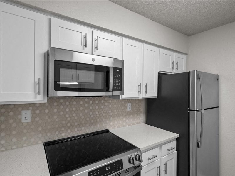 a kitchen with white cabinets and a stove and a refrigerator at Highland Park Apartment Homes, Kansas, 66214