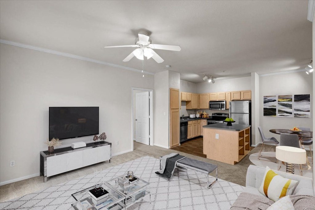 a living room with a ceiling fan and a kitchen