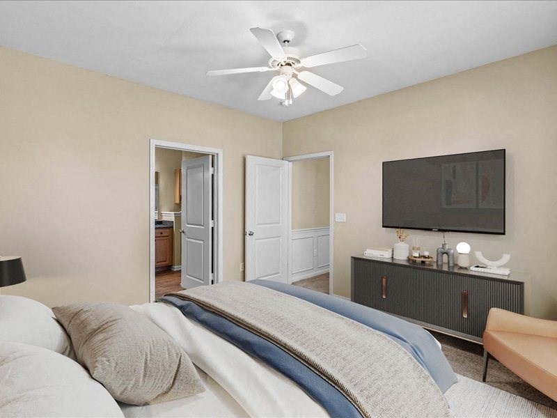 a bedroom with a large bed and a ceiling fan