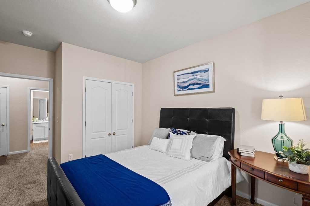 a bedroom with a bed and a nightstand with a lamp at Creekside, Overland Park, 66213