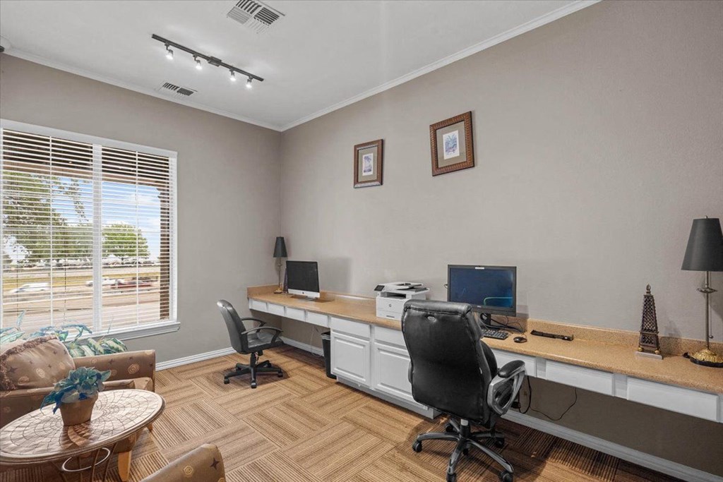 a home office with two computers and a coffee table at The Clairborne Apartment Homes, Texas