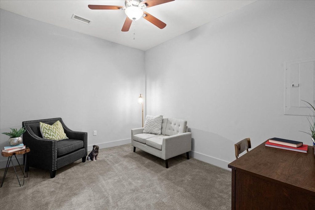 a living room with two chairs and a ceiling fan