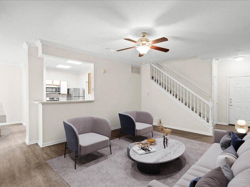 a living room with furniture and a ceiling fan