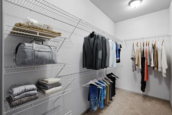 A large, well-lit, carpeted bedroom closet with wire rack shelves,