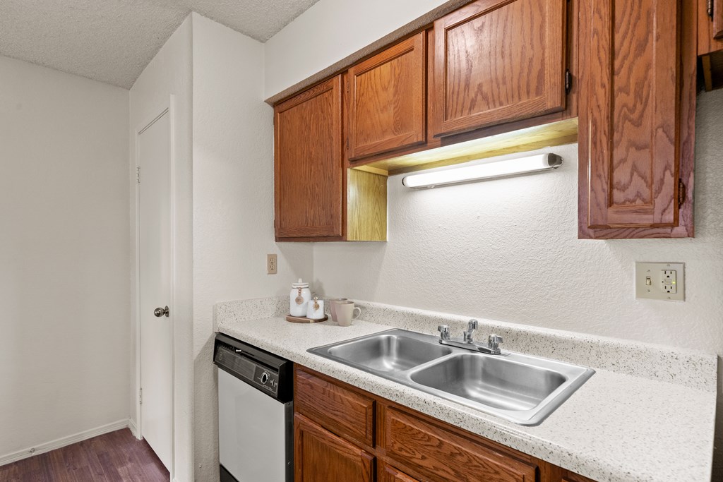 A kitchen with a white counter top and wooden cabinets. at Coventry Oaks Apartments, Overland Park, KS