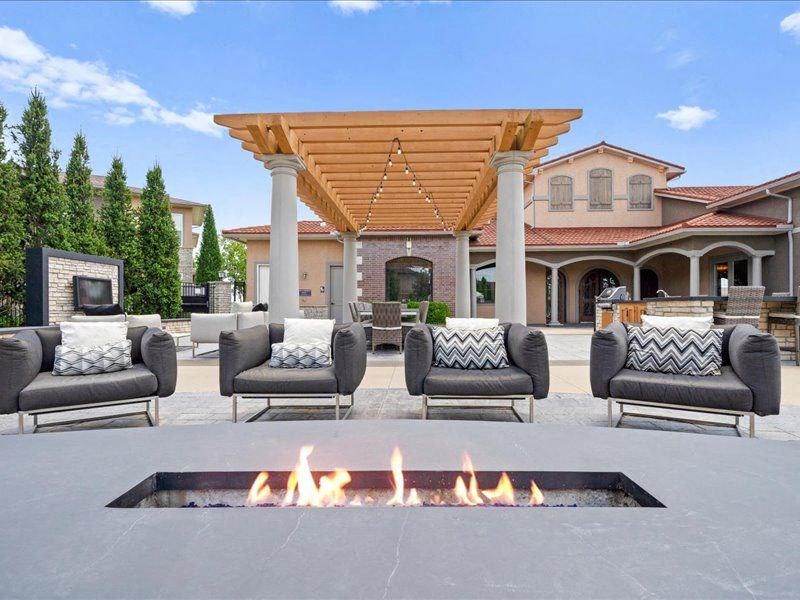 a patio with chairs and a fire pit
