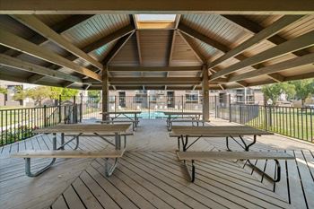 Picnic tables are arranged on a wooden deck.