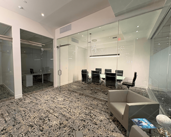 Spacious conference room area at Sky on Main Apartments, featuring a waiting area, two private workspaces, and a dedicated meeting room.