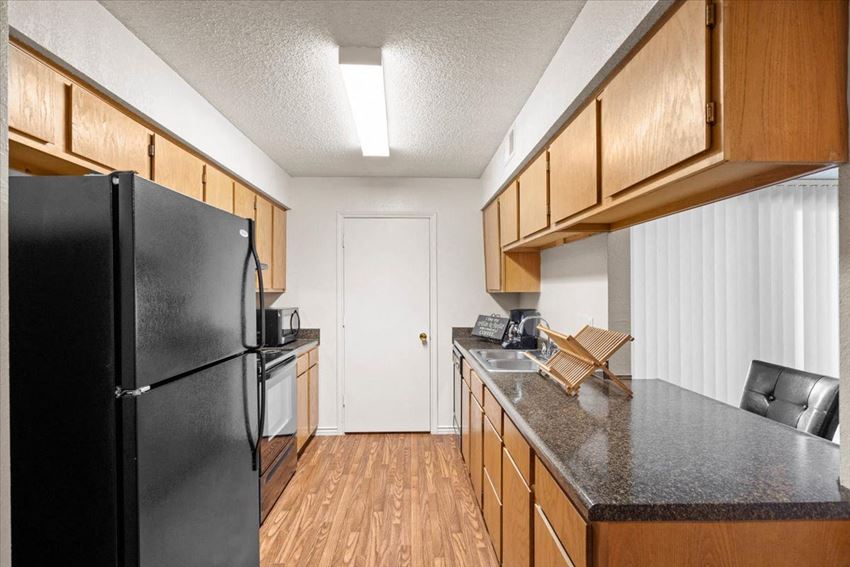 a kitchen with a black refrigerator and a counter top