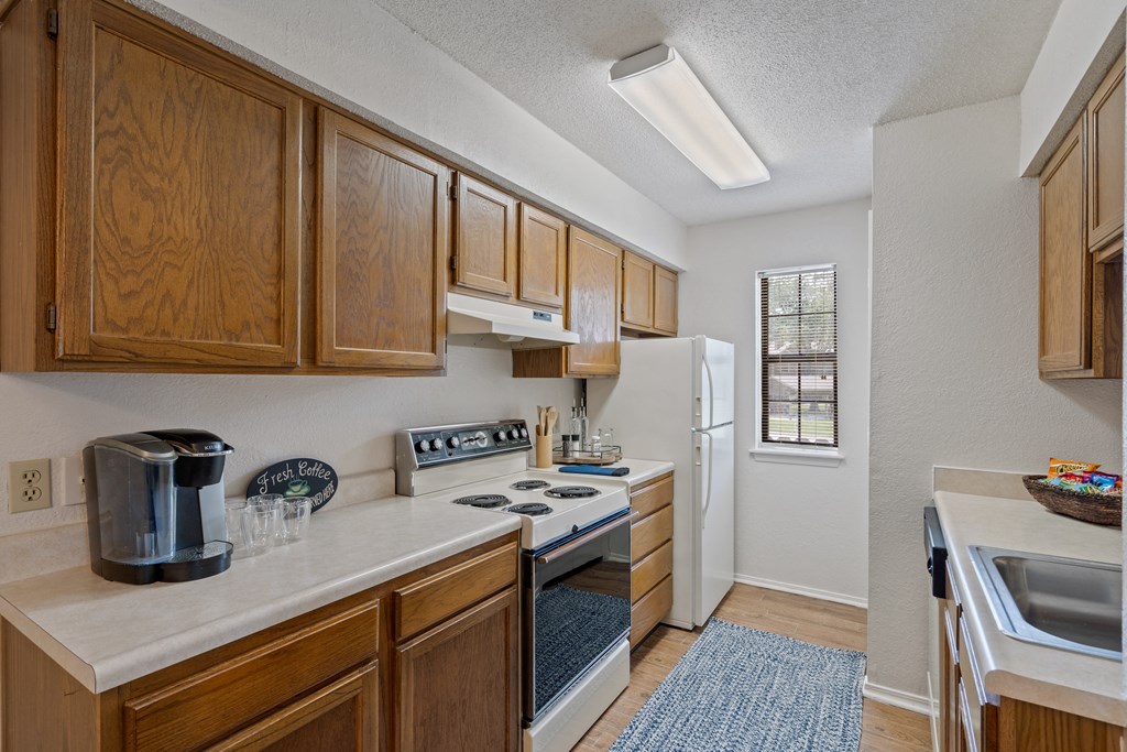a kitchen with a white refrigerator freezer next to a stove top oven at Waterford Place Apartments & Townhomes, Overland Park, KS