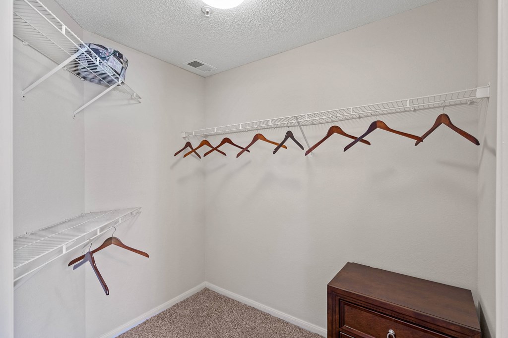 a walk in closet with a dresser and hangers  at Claremont, Overland Park, KS, 66210