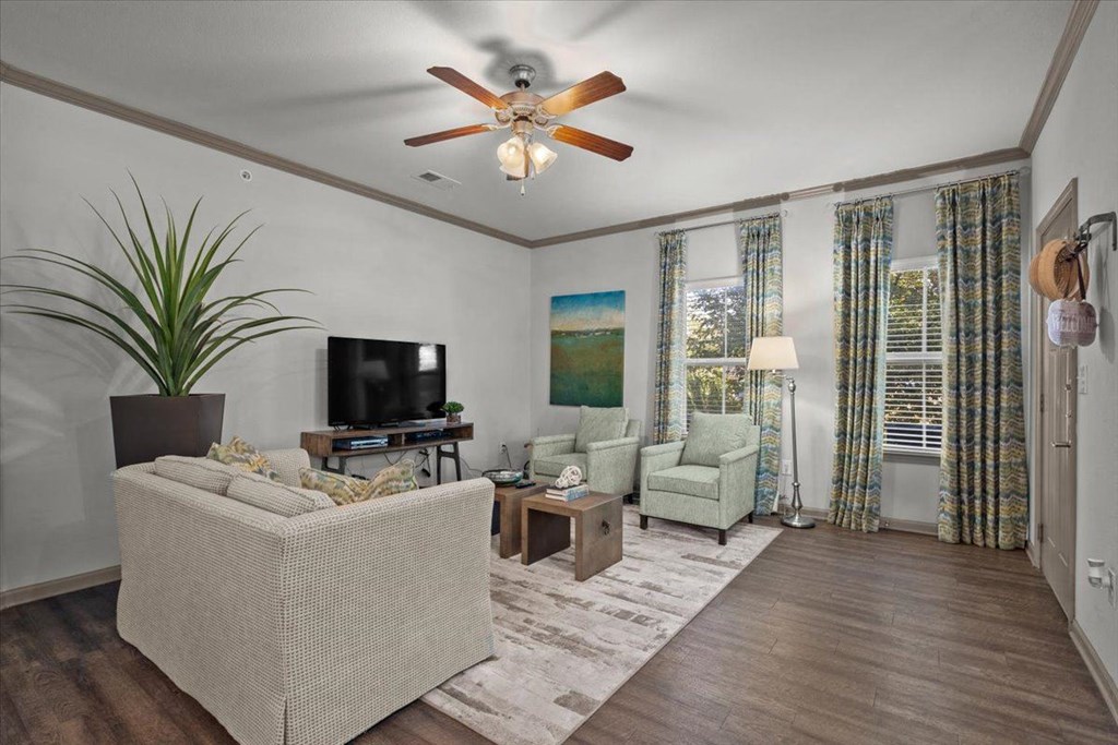 a living room with a ceiling fan and couches