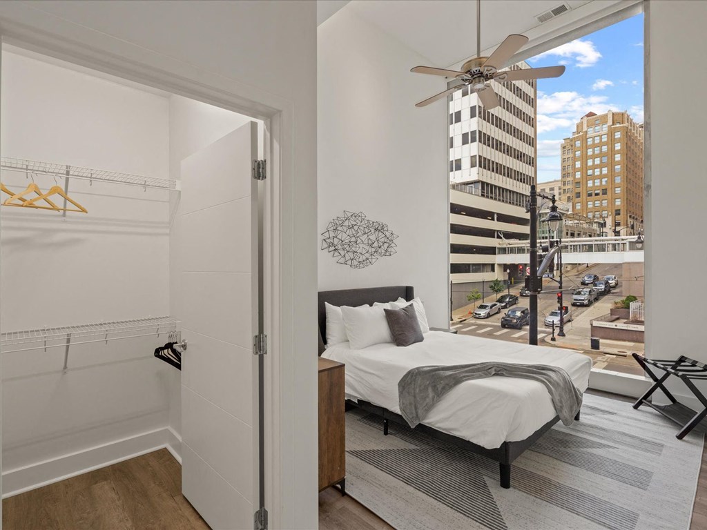 a bedroom with a large window and a city view at Sky On Main Apartments, Missouri