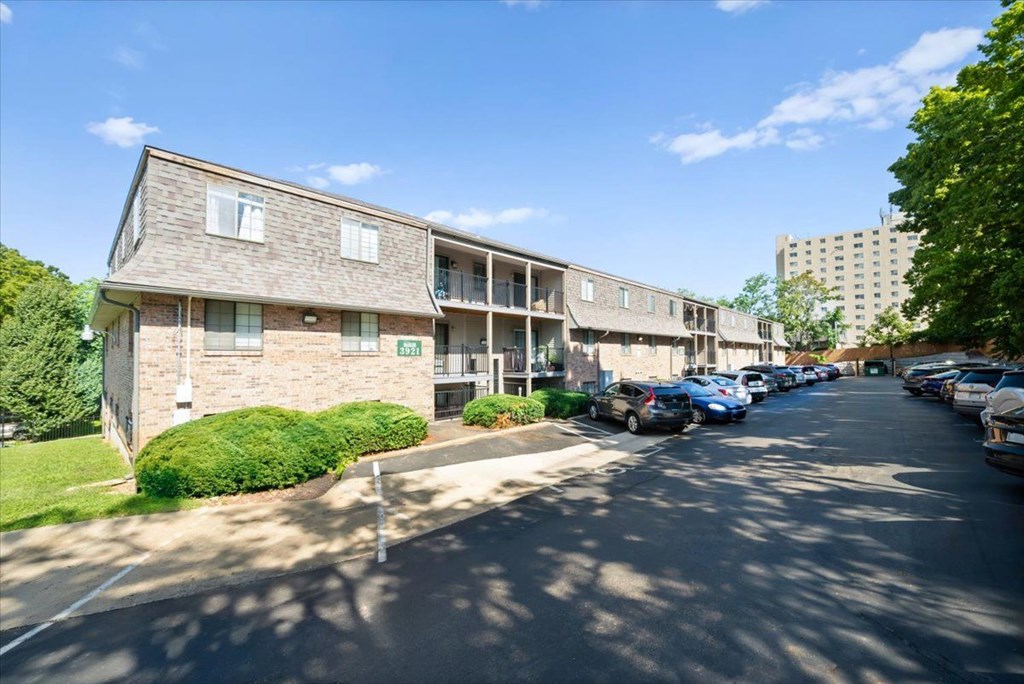 A sunny day at the apartment complex with cars parked on the street. at Malvern Hill Apartment Homes, 66103, Kansas
