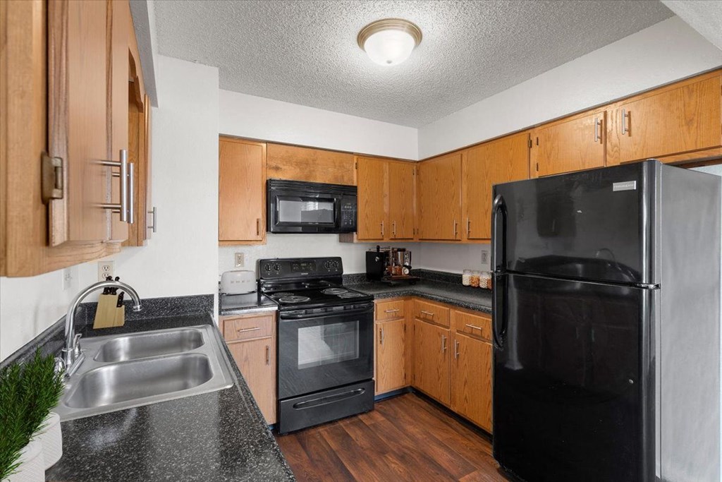 a kitchen with black appliances and wooden cabinets