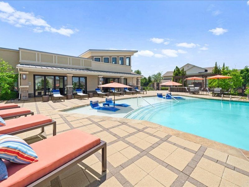 a swimming pool with lounge chairs and umbrellas
