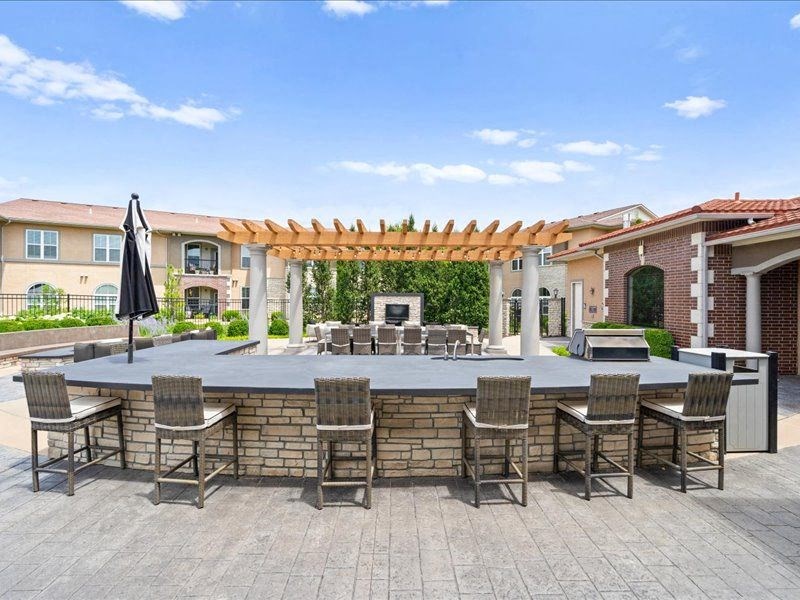 a large outdoor entertaining area with a bar and tables