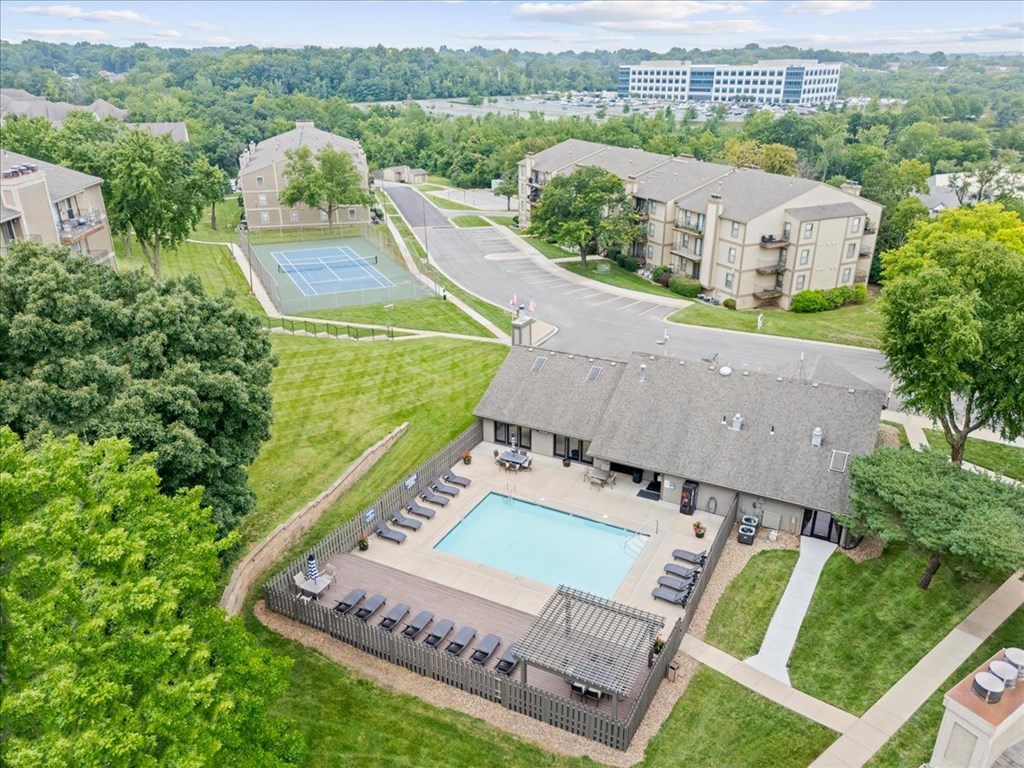 A large apartment complex with a pool and tennis court.