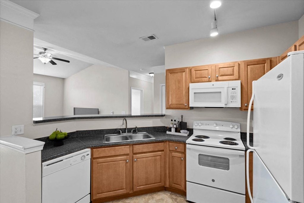 a kitchen with white appliances and wooden cabinets