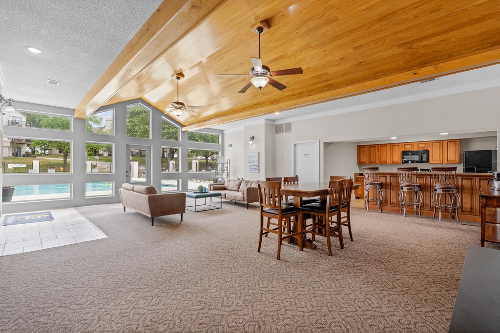a large living room with a vaulted ceiling and large windowsat Millcreek Woods Apartments, Olathe, KS