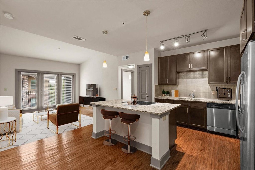 an open kitchen and living room with a large island at Cypress at Lewisville Apartment Homes, Texas